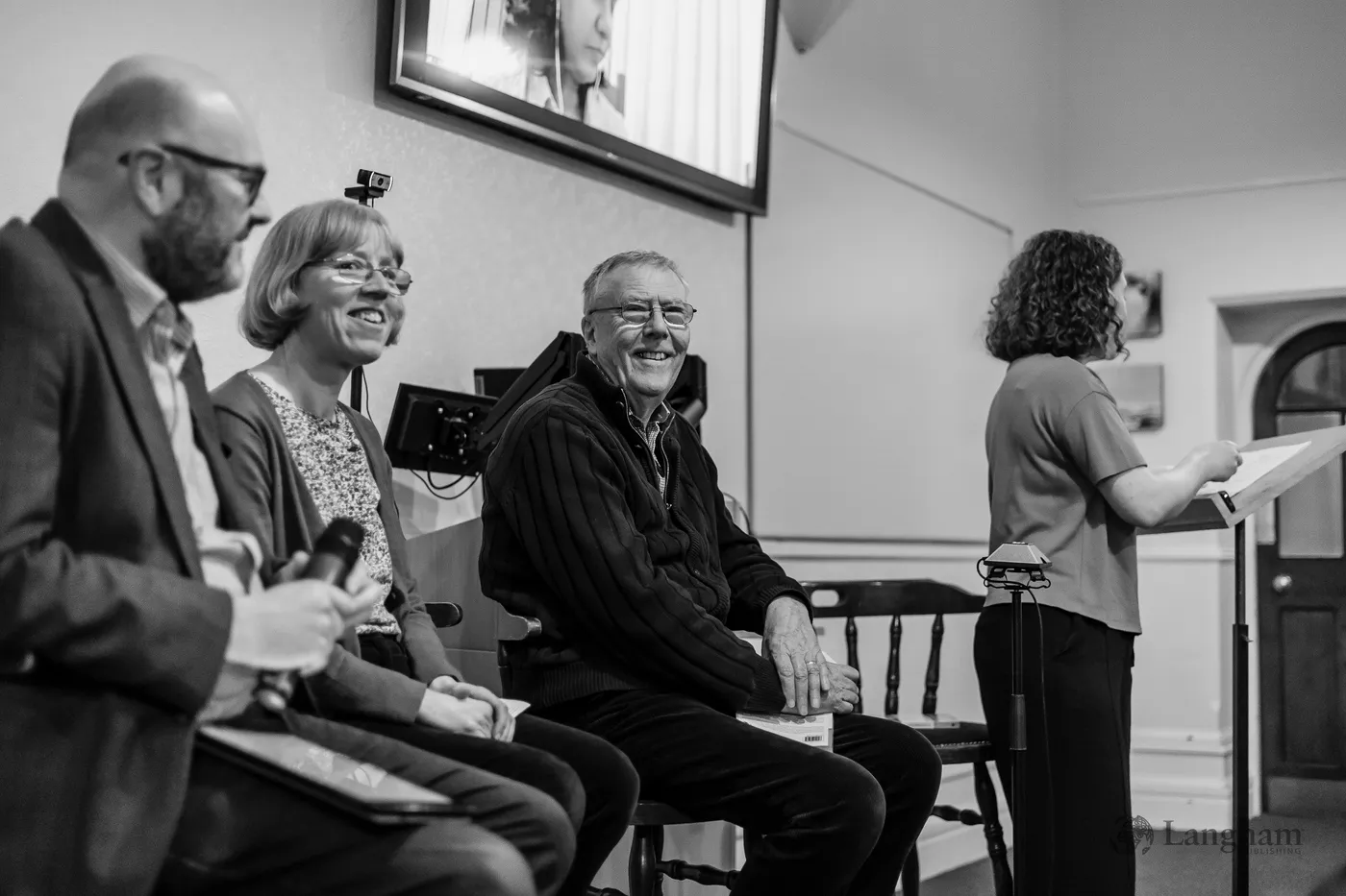 The launch panel seated at the front of the hall, sharing a laugh as the discussion opens.