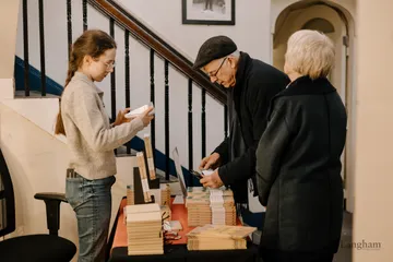 Copies of Justice and Rights stacked on the book table as guests collect them.